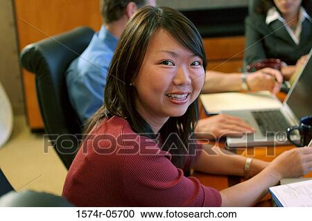 Stock Image - Group of business executives sitting in a conference room. Fotosearch