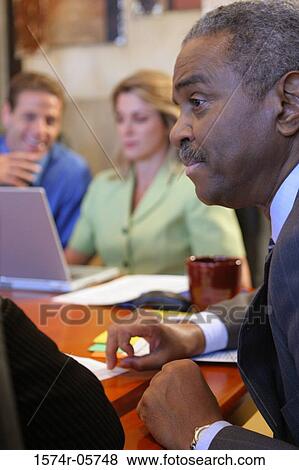 Group of business executives sitting in a conference room View Large Photo Image Stock Photo - Group of business executives sitting in a conference room. Fotosearch
