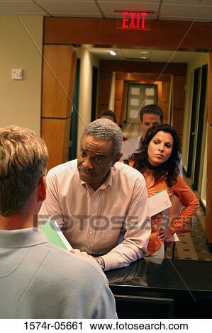 Group of business executives standing in a row at a bank counter View Large Photo Image Stock Image - Group of business executives standing in a row at a bank counter. Fotosearch