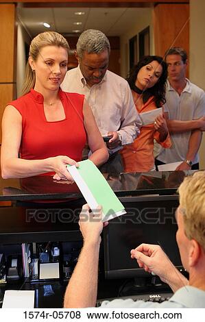 Group of business executives standing in a row at a bank counter View Large Photo Image Stock Photo - Group of business executives standing in a row at a bank counter. Fotosearch