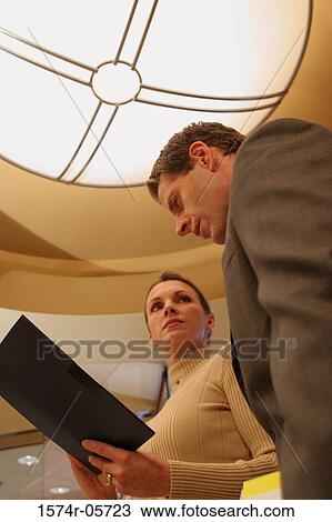 Low angle view of a businessman talking to a businesswoman View Large Photo Image Stock Image - Low angle view of a businessman talking to a businesswoman. Fotosearch
