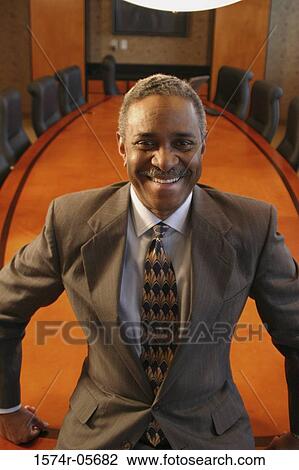 Portrait of a businessman standing in a conference room smiling View Large Photo Image Stock Image - Portrait of a businessman standing in a conference room smiling. Fotosearch