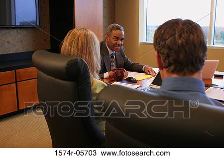 Two businessmen and a businesswoman in a conference room View Large Photo Image Stock Image - Two businessmen and a businesswoman in a conference room. Fotosearch