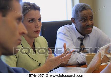 Two businessmen and a businesswoman sitting in a conference room View Large Photo Image Stock Image - Two businessmen and a businesswoman sitting in a conference room. Fotosearch