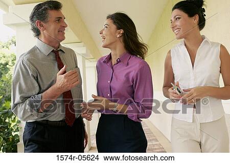 Two businesswomen and a businessman walking in corridor View Large Photo Image Picture - Two businesswomen and a businessman walking in corridor. Fotosearch