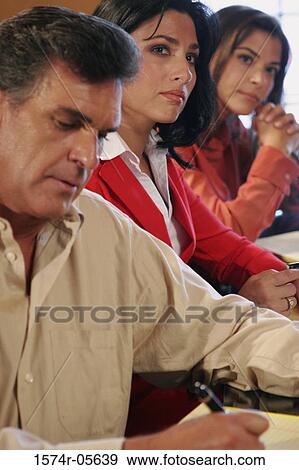 Two businesswomen and a businessman sitting in a conference room View Large Photo Image Stock Photo - Two businesswomen and a businessman sitting in a conference room. Fotosearch