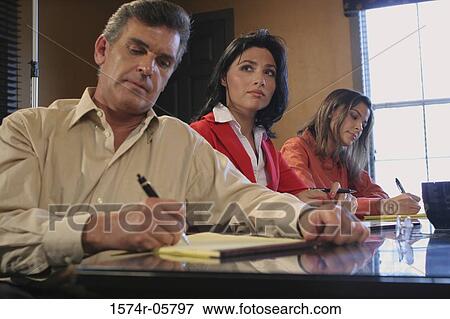 Two businesswomen and a businessman sitting in a conference room View Large Photo Image Stock Photo - Two businesswomen and a businessman sitting in a conference room. Fotosearch