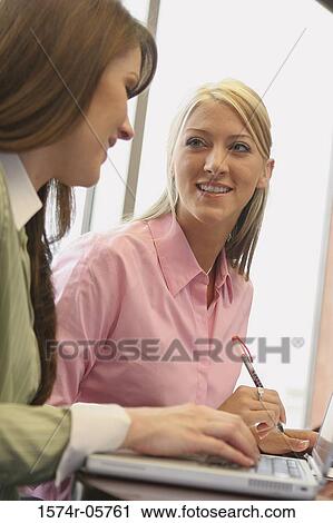 Stock Image - Two businesswomen looking at each other. Fotosearch