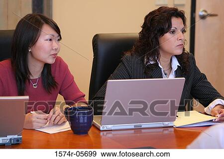 Stock Photo - Two businesswomen sitting in a conference room. Fotosearch