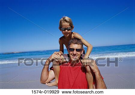 Father carrying his son on his shoulders View Large Photo Image Stock Photo - Father carrying his son on his shoulders. Fotosearch