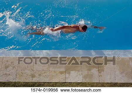 Stock Photograph - High angle view of a young man swimming in a pool. Fotosearch