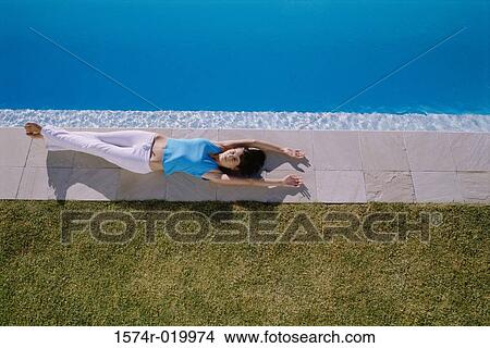 High angle view of a young woman lying at the poolside View Large Photo Image Picture - High angle view of a young woman lying at the poolside. Fotosearch