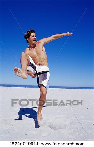 Young man playing frisbee on the beach View Large Photo Image Picture - Young man playing frisbee on the beach. Fotosearch