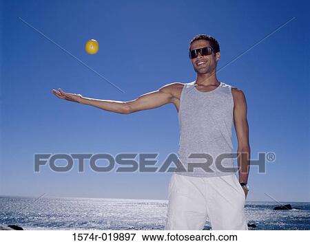 Stock Photo - Young man playing with a ball. Fotosearch