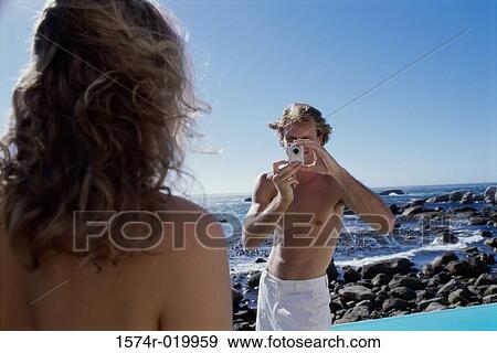 Young man taking a photograph of a young woman View Large Photo Image Stock Photo - Young man taking a photograph of a young woman. Fotosearch