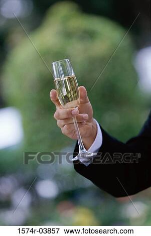 Close-up of a person's hand holding a champagne flute View Large Photo Image Stock Photo - Close-up of a person's hand holding a champagne flute. Fotosearch