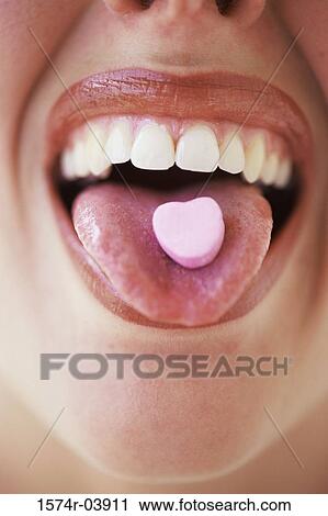Close-up of a young woman's mouth with a candy on her tongue View Large Photo Image Stock Image - Close-up of a young woman's mouth with a candy on her tongue. Fotosearch