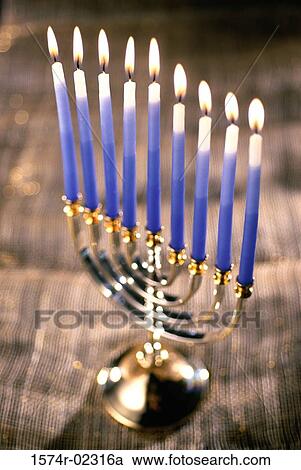 Stock Image - Close-up of lit candles on a menorah. Fotosearch