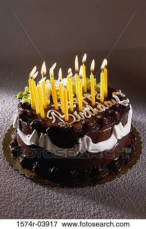Stock Photo - Decorated birthday cake with lit candles. Fotosearch