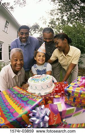 Stock Photo - Girl celebrating her birthday with her parents and grandparents. Fotosearch