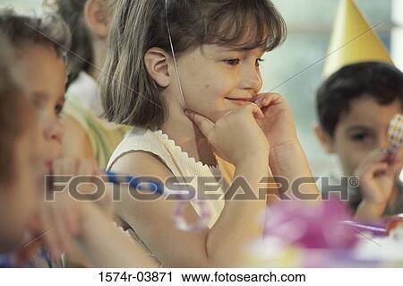 Stock Image - Group of children blowing party horn blower at a birthday party. Fotosearch