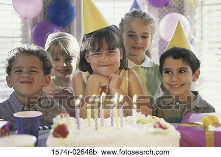 Group of children in front of a birthday cake at a birthday party View Large Photo Image Stock Image - Group of children in front of a birthday cake at a birthday party. Fotosearch