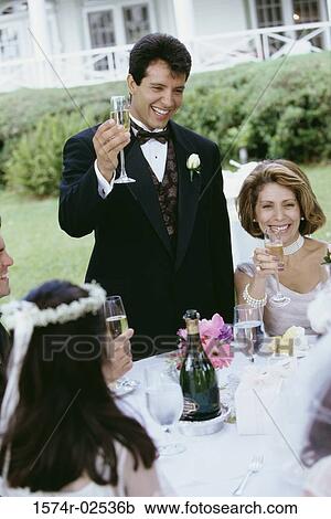 Stock Image - Group of people at a wedding toasting with glasses of champagne. Fotosearch