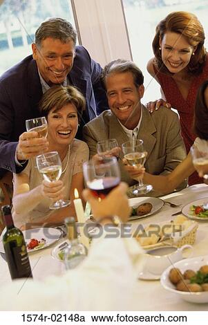 Stock Image - Group of people celebrating with glasses of wine. Fotosearch