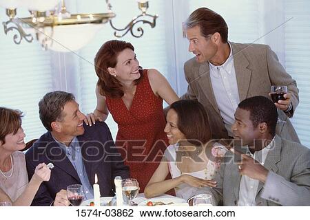 Group of people drinking at a dining table View Large Photo Image Stock Image - Group of people drinking at a dining table. Fotosearch