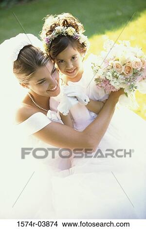 Picture - High angle view of a bride smiling with a flower girl. Fotosearch