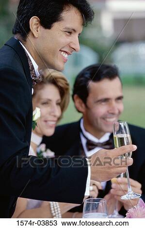 Newlywed young man toasting champagne with mid adult couple View Large Photo Image Stock Image - Newlywed young man toasting champagne with mid adult couple. Fotosearch