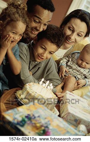 Stock Image - Parents with their children in front of a birthday cake. Fotosearch