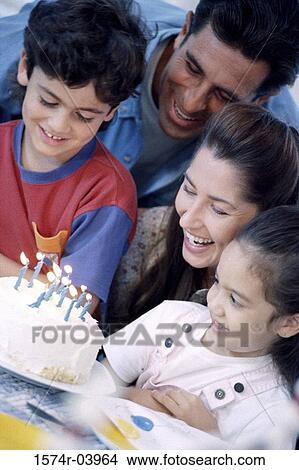 Picture - Parents with their son and daughter in front of a birthday cake. Fotosearch