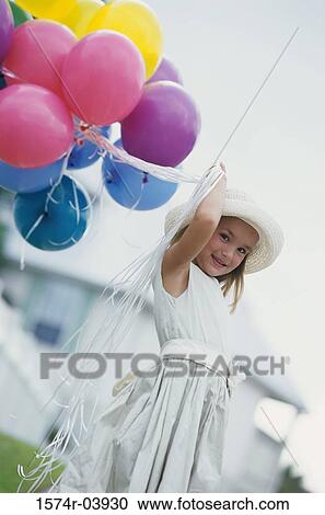 Stock Image - Portrait of a girl holding balloons. Fotosearch