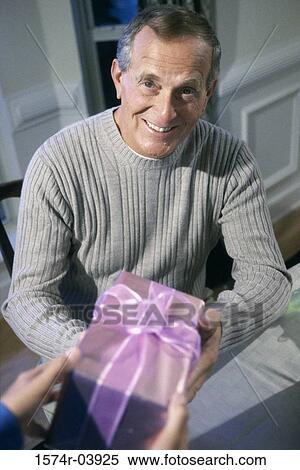 Portrait of a senior man receiving a gift View Large Photo Image Stock Photography - Portrait of a senior man receiving a gift. Fotosearch