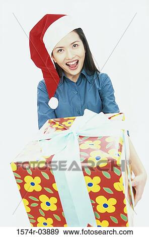 Portrait of a young woman holding a gift View Large Photo Image Stock Photo - Portrait of a young woman holding a gift. Fotosearch