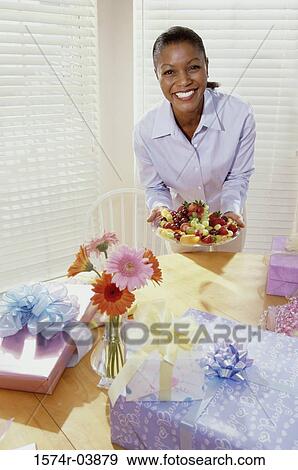 Portrait of a young woman holding a plate of fruits View Large Photo Image Stock Photo - Portrait of a young woman holding a plate of fruits. Fotosearch