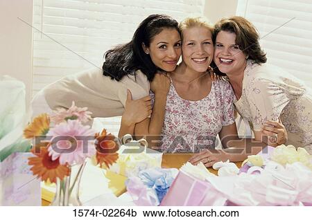 Stock Image - Portrait of three young women at a baby shower. Fotosearch