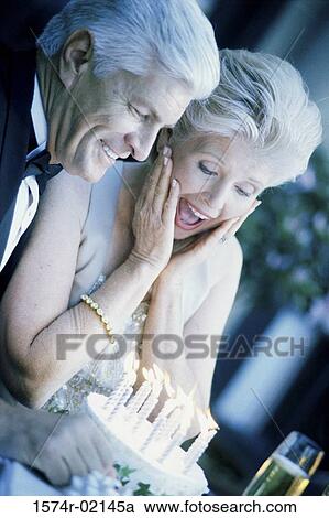 Stock Image - Senior couple with a birthday cake. Fotosearch