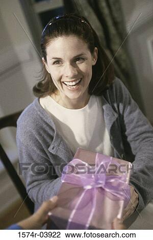 Young woman receiving a gift View Large Photo Image Stock Image - Young woman receiving a gift. Fotosearch