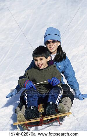 Stock Image - Boy and a girl riding a sled. Fotosearch