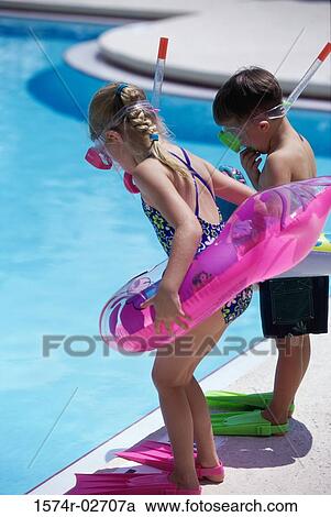 Boy and a girl standing at the poolside wearing snorkels and flippers View Large Photo Image Stock Image - Boy and a girl standing at the poolside wearing snorkels and flippers. Fotosearch