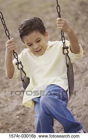 Stock Image - Boy sitting on a swing. Fotosearch