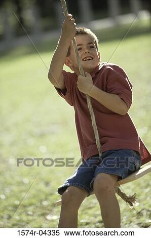 Boy sitting on a swing View Large Photo Image Stock Photography - Boy sitting on a swing. Fotosearch