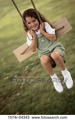 Close-up of a girl sitting on a swing View Large Photo Image Stock Image - Close-up of a girl sitting on a swing. Fotosearch