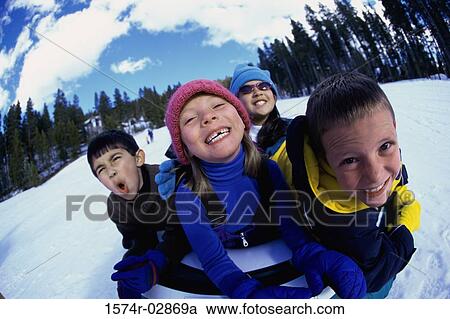 Close-up of two boys and two girls riding on a sled View Large Photo Image Stock Image - Close-up of two boys and two girls riding on a sled. Fotosearch