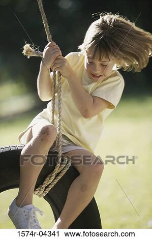 Girl sitting on a tire swing View Large Photo Image Stock Image - Girl sitting on a tire swing. Fotosearch