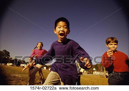 Group of children running in a park View Large Photo Image Stock Image - Group of children running in a park. Fotosearch