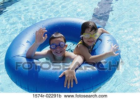 High angle view of a boy and a girl in an inflatable ring in a swimming pool View Large Photo Image Stock Image - High angle view of a boy and a girl in an inflatable ring in a swimming pool. Fotosearch