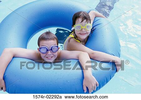 High angle view of a boy and a girl in an inflatable ring in a swimming pool View Large Photo Image Stock Image - High angle view of a boy and a girl in an inflatable ring in a swimming pool. Fotosearch